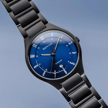Zwart titanium bering titanium comfort horloge met blauwe glanzende wijzerplaat en zileren cijfers en een datum raampje bij de 6