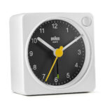 Braun BC02XWB wit zwarte reiswekker zijaanzicht met gele secondewijzer.