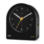 Braun Classic Analogue BC22B zijaanzicht zwarte wekker met witte en gele details.